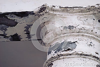 Old abandoned cracked column capital with peel of the paint. Fragment Stock Photo