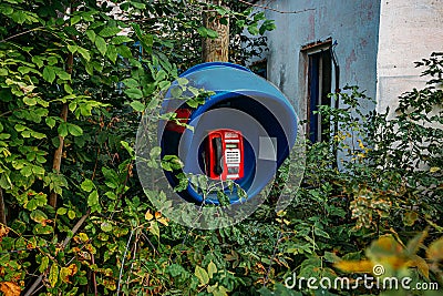 Old abandoned overgrown phone booth Stock Photo