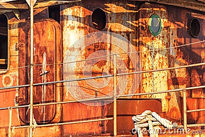 Old abandoned rusted ship moored to the pier in the seaport close up Stock Photo