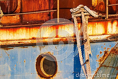 Old abandoned rusted ship moored to the pier in the seaport close up Stock Photo