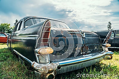 Old abandoned rusty car rusting on green grass Editorial Stock Photo