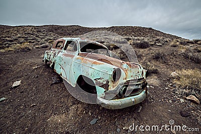 Old abandoned rusty car from 60`s in the desert. Stock Photo