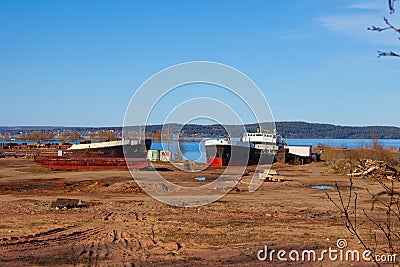 Old, abandoned ships in the port on a background of blue lake Stock Photo