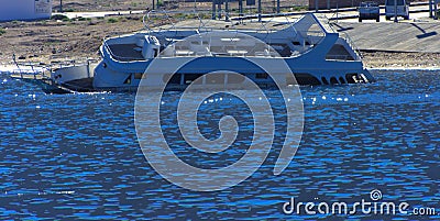 An old abandoned white sea yacht sank in the Red Sea against the blue sky of old coral reefs Stock Photo