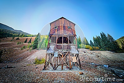 Old abandoned wood mining building tucked into the empty mountains Stock Photo