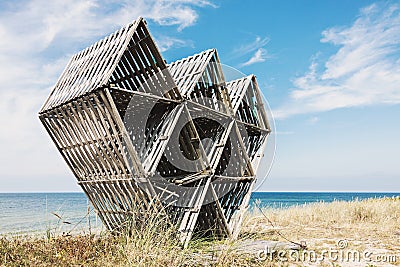 Abandoned wooden geometric sculpture on wild beach Stock Photo