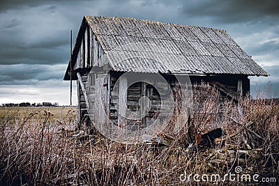 Old abandoned wooden house in a view of dark cloudy sky Stock Photo