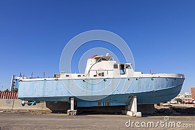 Old abandoned wrecked speed boat at ship or boat graveyard. Lots of different dry docked, destroyed, weathered, old, abandoned boa Stock Photo