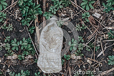 Old aged plastic bottle garbage on ground in green grass. Trash litter dump in a forest park. Ecological environmental world Stock Photo