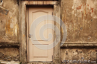 Old aged white door in weathered dirty wall Stock Photo