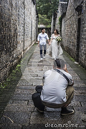 In an old alley in the east gate of Laomen, a photographer taking a wedding photo Editorial Stock Photo