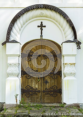 Old ancient gothic wooden church door with metal ornaments and cross on it Stock Photo