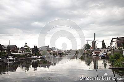 Old ancient windmill along river Old Rhine in city of Bodegraven whch became beer brewery. Stock Photo