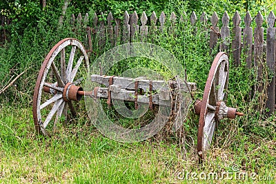 Old Animal Drawn Cart. Decorative old wheels from a rural cart. Old wooden cart inside a country garden Stock Photo
