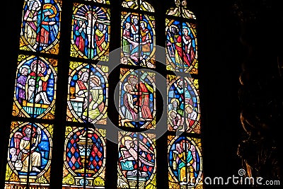 Old antique colorful stained glass windows in a darkened church, saints, bible scenes religious art decoration detail, closeup Editorial Stock Photo