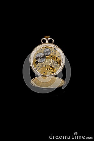 Old antique mechanical golden steel pocket watch with open lid isolated on black background. Stock Photo