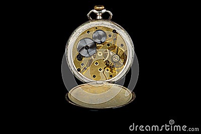 Old antique mechanical golden steel pocket watch with open lid isolated on black background. Stock Photo