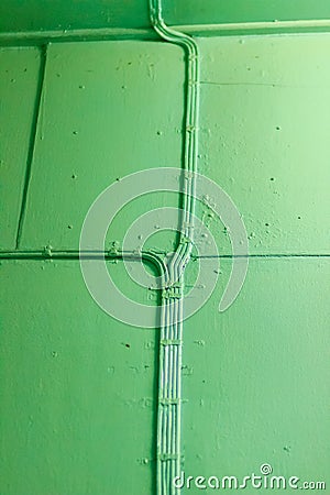 Old aqua wall crossed by an electric cable of the same color. Th Stock Photo