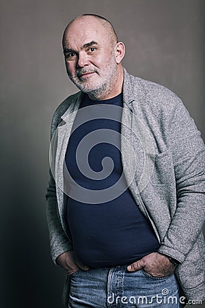 Old bald gray-haired smiling modern man in fashionable clothes Stock Photo