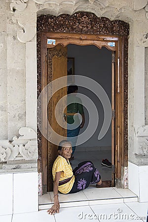 Old balinese woman sitting in door Editorial Stock Photo