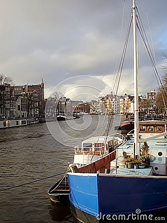 Old barges converted to houseboats on the canals of Amsterdam in Stock Photo