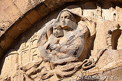 An old baroque engraved sculpture of Mary and Jesus over an entrance to the Cappella della Croce di Giorno in Volterra Stock Photo