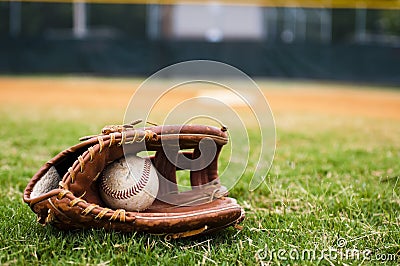 Old Baseball and Glove on Field Stock Photo