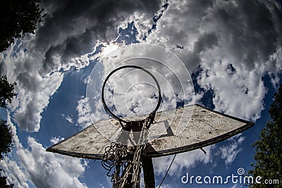 Old basketball court, basket, snatched netting against the sky Stock Photo