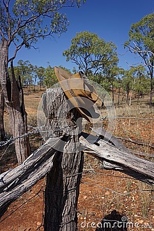 Old beaten up Australian bushmans` hat on fence. Stock Photo