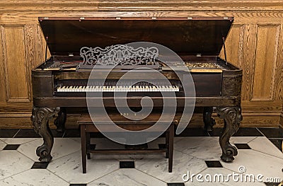 old beautiful gorgeous vintage grand piano standing against wooden background Stock Photo