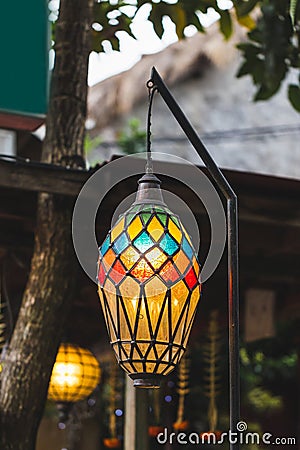 Old beautiful hanging lamp outside in cafe garden made from stained glass Stock Photo