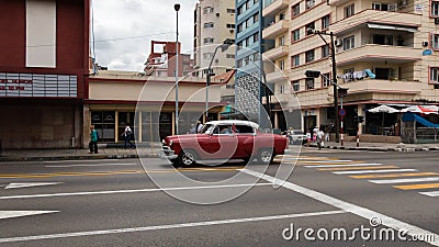 An old and beautiful red car driving through the streets of Havana Editorial Stock Photo