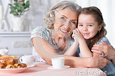 Old woman with a young girl drinking tea Stock Photo