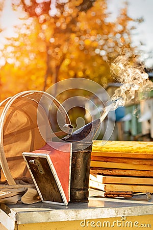 Old bee smoker. Beekeeping tool. Autumn in an apiary. Theme of beekeeping. Stock Photo