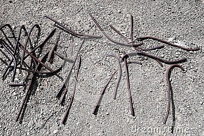 Old bent rusty rebars sticking out of the gray stony ground Stock Photo