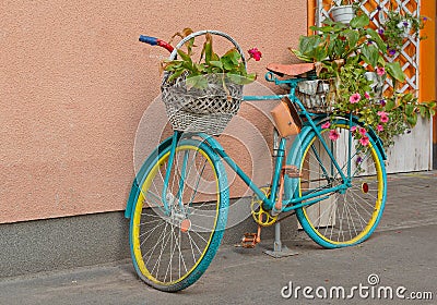 Old bicycle with flowers and a basket by the wall Stock Photo