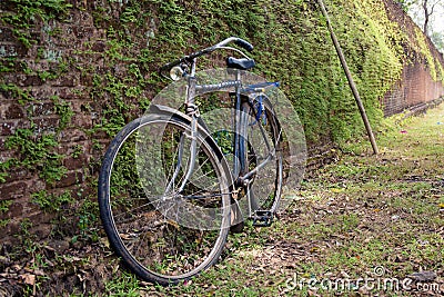 An old bicycle leaning against one of the old brick walls of the Stock Photo