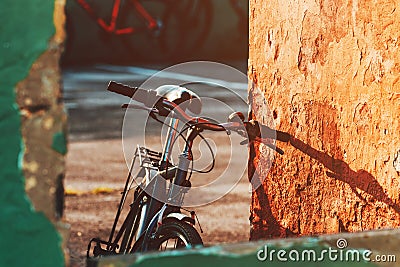 Old bicycle leaning on the worn wall Stock Photo
