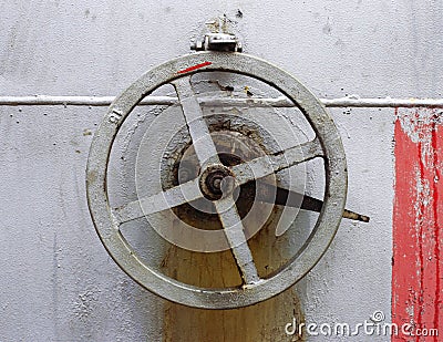 Old big hand wheel on the wall of tank Stock Photo