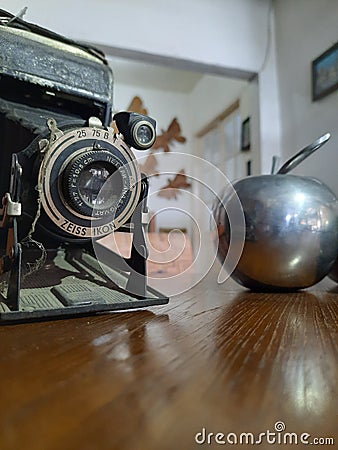 Old black camera and silver apple Editorial Stock Photo