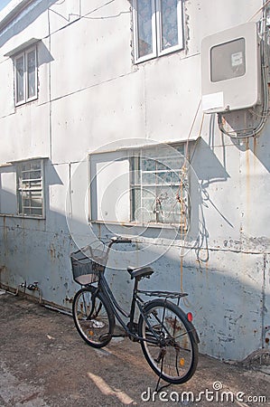 Old black classical vintage family bicycle parks near an old hou Stock Photo