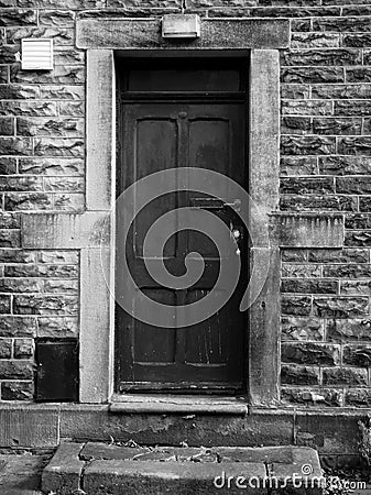 Old black door with faded and flaking paintwork Stock Photo