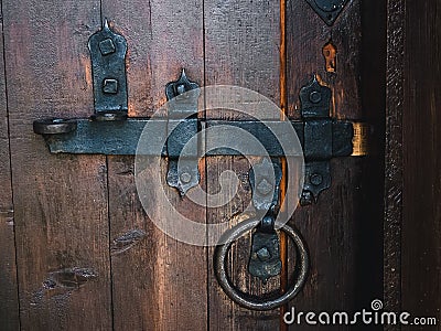 Old black metal deadbolt on a wooden door Stock Photo