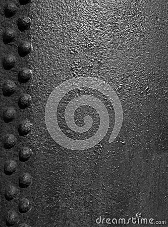 Old black rough iron metal surface with grainy texture and lines of rivets Stock Photo