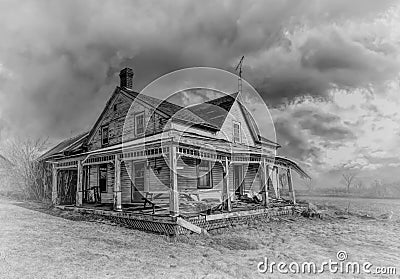 Old black and white abandoned spooky looking house in winter on a farm yard in rural Canada Stock Photo