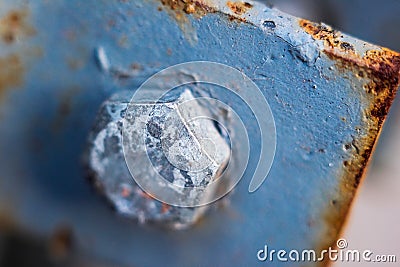 Old blue bolt on metal rusty plate close-up, soft focus Stock Photo