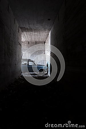 An old blue car in an abandoned concrete catacomb Stock Photo