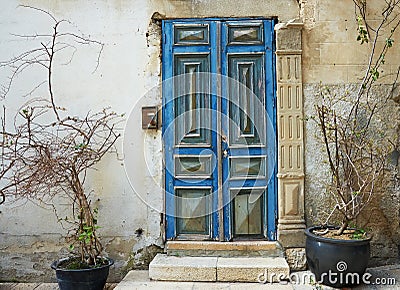 Old blue door against an old stone wall Stock Photo