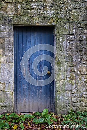 Old blue door in stone wall Stock Photo