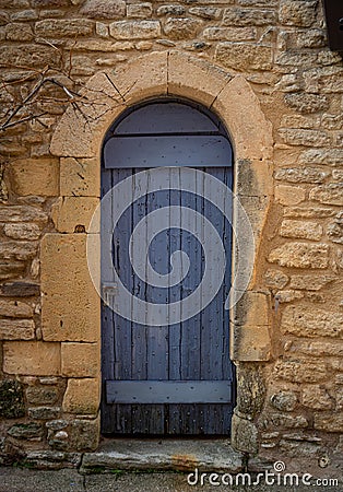 Old blue door in yellow stone wall with padlock Stock Photo